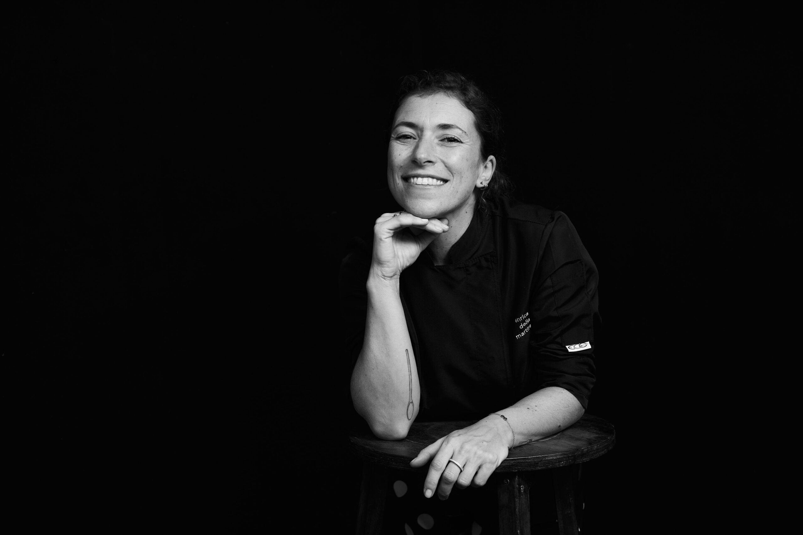 chef che sorride su uno sgabello